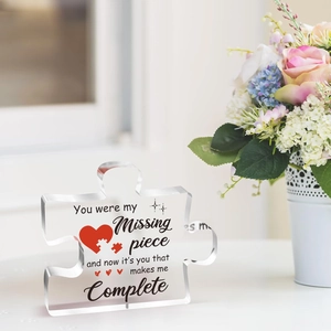 Macro shot of clear acrylic puzzle piece ornament with romantic engraving and heart pattern
