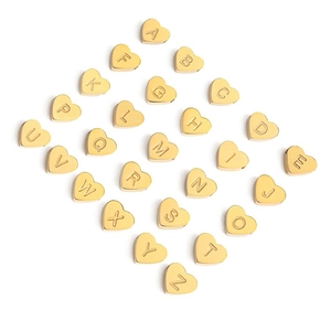 Detailed view of gold stainless steel heart pendants with A-Z alphabet engravings