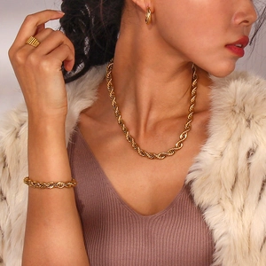 Close-up of golden twisted rope jewelry set including necklace, bracelet and ring