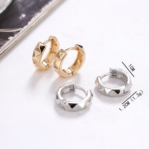 Detail view of 1cm wide geometric pyramid pattern hoop earrings in gold and silver