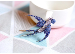 Dettaglio di una spilla a rondine con strass blu e uno stile vintage elegante