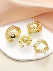 Detailed view of four adjustable gold-plated rings with sunflower and zircon stones