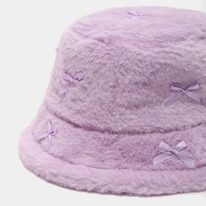 Detail of purple plush bucket hat with soft faux fur texture and satin bow accents