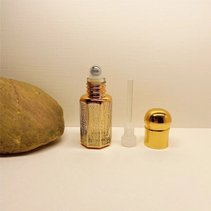 Disassembled laser coated crystal perfume roller bottle with ornate gold metal casing