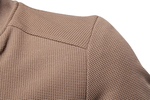 Macro shot of brown waffle knit fabric shoulder seam on a slim fit men jacket