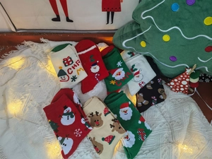 Dettaglio calzini natalizi in cotone con motivi festivi di renne e Babbo Natale