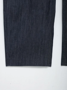 Primo piano dettagliato dei jeans blu scuro che mostrano la trama del twill e le cuciture laterali