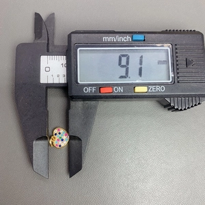Macro view of 9.1mm heart pendant with colorful crystals being measured by a caliper