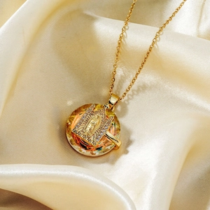 Golden Virgin Mary necklace with colored crystal pendant and white stones on silk background