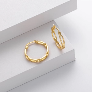 Close-up of S925 sterling silver stamp on golden chain link style hoop earrings