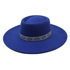 Royal blue wide brim wool fedora hat with geometric patterned ribbon on white background