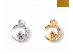 Close-up of gold and silver moon charms with sun centers and pink rhinestones