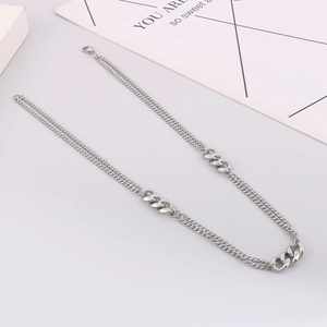 Detail view of silver stainless steel double layered Cuban chain and sleek link necklace