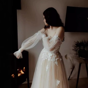 Elegant off-shoulder wedding dress with lace puff sleeves and floral appliques on tulle