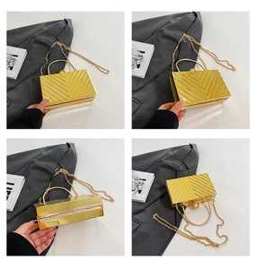 Detailed view of golden acrylic evening clutch featuring V-texture and pearl clasp