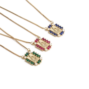 Three gold pendant necklaces with embossed figures and vibrant colorful crystals