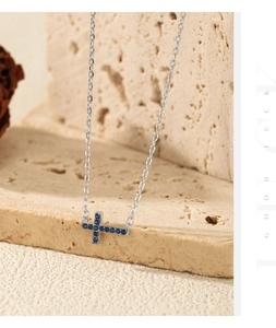 Détail macro du collier croix en argent S925 avec cristaux de saphir bleu profond