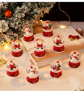 Close-up of festive Christmas snow globes with Santa and snowman on a cozy holiday tabletop