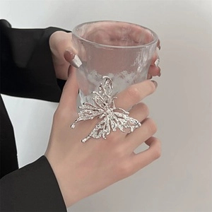 Detail of silver butterfly ring featuring irregular pleated textures and artistic design