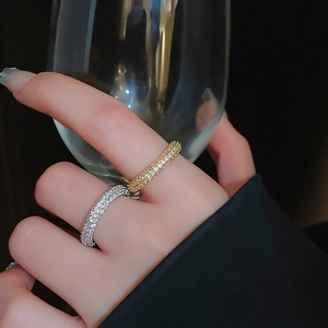 Close-up of gold and silver twisted rings with cubic zirconia stones on hand