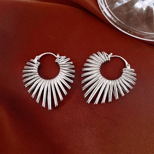 Detail view of silver fan-shaped zircon earrings on a premium red silk background