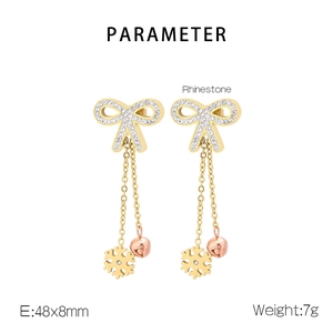 Detail view of rhinestone bow earrings with snowflake and bell charms, size 48x8mm