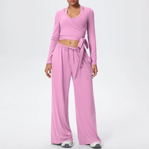 Détail de l'ensemble de yoga rose montrant le haut croisé et le pantalon large taille haute