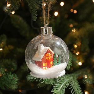 Bola de Navidad transparente con luces LED y casa en miniatura colgada del árbol