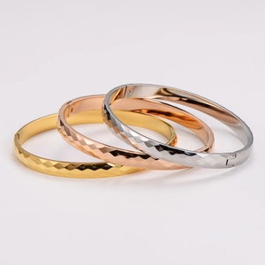 Three-piece diamond-cut stainless steel bangles in gold, rose gold, and silver finishes