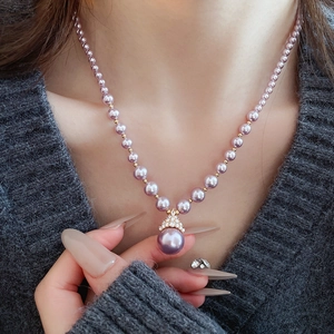 Vue détaillée d'un collier de perles mauves avec un grand pendentif sur un mannequin