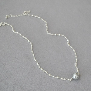 Detailed view of silver chain necklace featuring a grey pearl pendant and adjustable clasp
