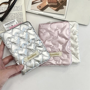 Quilted heart texture passport holder in silver pink and pearl white with brand label