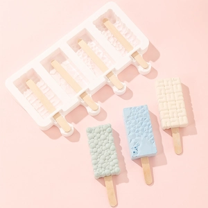Silicone ice cream mold with textured patterns and finished popsicles on pink background