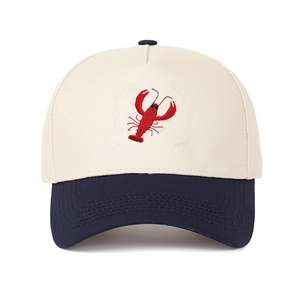 Close-up of lobster embroidery and contrasting blue brim on the beige cotton baseball cap