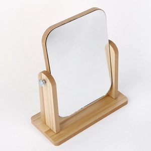 Detail of adjustable wooden desktop vanity mirror with rounded rectangular glass surface