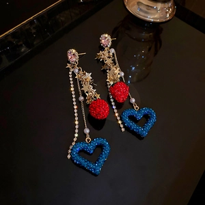 Macro view of crystal tassels with strawberry red orb and blue hollow heart pendant
