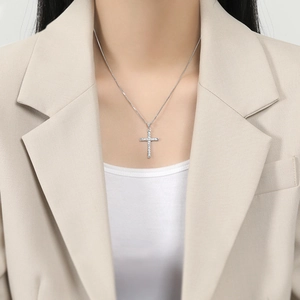Classic silver cross pendant necklace with clear sparkling stones on a stylish model