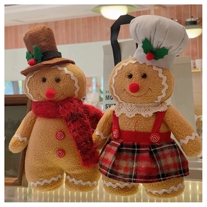Detail of standing plush gingerbread couple with chef hats and scarves for Christmas decor