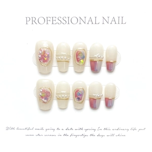 Macro detail of French style long press-on nails with pink ombre and pearl decorations