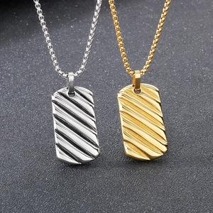 Macro detail of gold and silver rectangular bar pendants with textured diagonal stripes