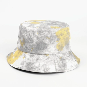 Close-up of tie-dye bucket hat with grey and yellow patterns on twill canvas fabric