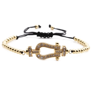Elegant gold horseshoe bracelet with zircon pavé and adjustable black cord band