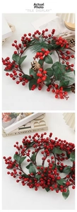 Detailed close-up of artificial red berries with green pine needles and pine cones