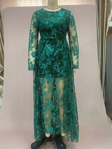 Detail of dark green lace dress showing intricate floral sequin embroidery and mesh fabric
