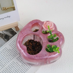 Detalle de bandeja de resina con forma de pata de gato y purpurina rosa decorada