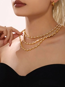 Elegant multi-layer gold chain necklace with pearls on a model for jewelry display