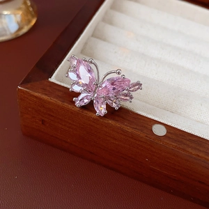 Détail d'une bague papillon en argent avec des zircons roses dans un écrin à bijoux