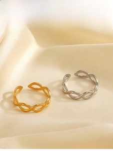 Détail de bagues torsadées en or 18 carats et argent sur fond de tissu satiné