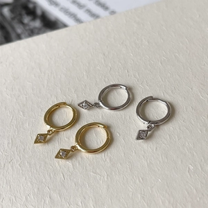 Detail of rhombus S925 sterling silver hoop earrings with cubic zirconia in gold and silver