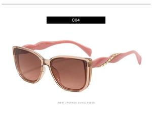 Detail view of large champagne sunglasses with golden twisted texture temples and brown lenses